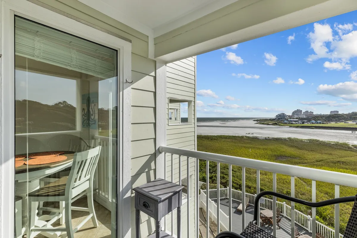 A peaceful view from a dining area overlooking a marsh, with chairs and decorative wall art visible. The scene evokes a sense of enjoying warm, sunlit spaces and the calming effect of nature, even when indoors.