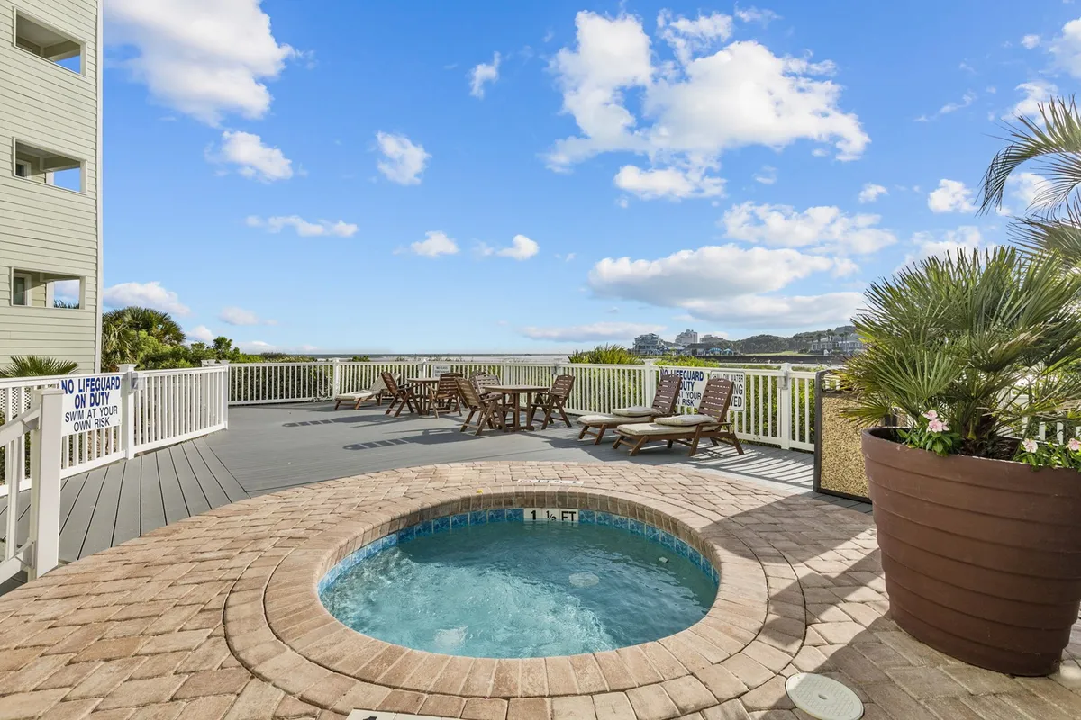 A tranquil hot tub area facing the water, with comfortable lounge chairs arranged strategically to enjoy the sunset views and peaceful surroundings.